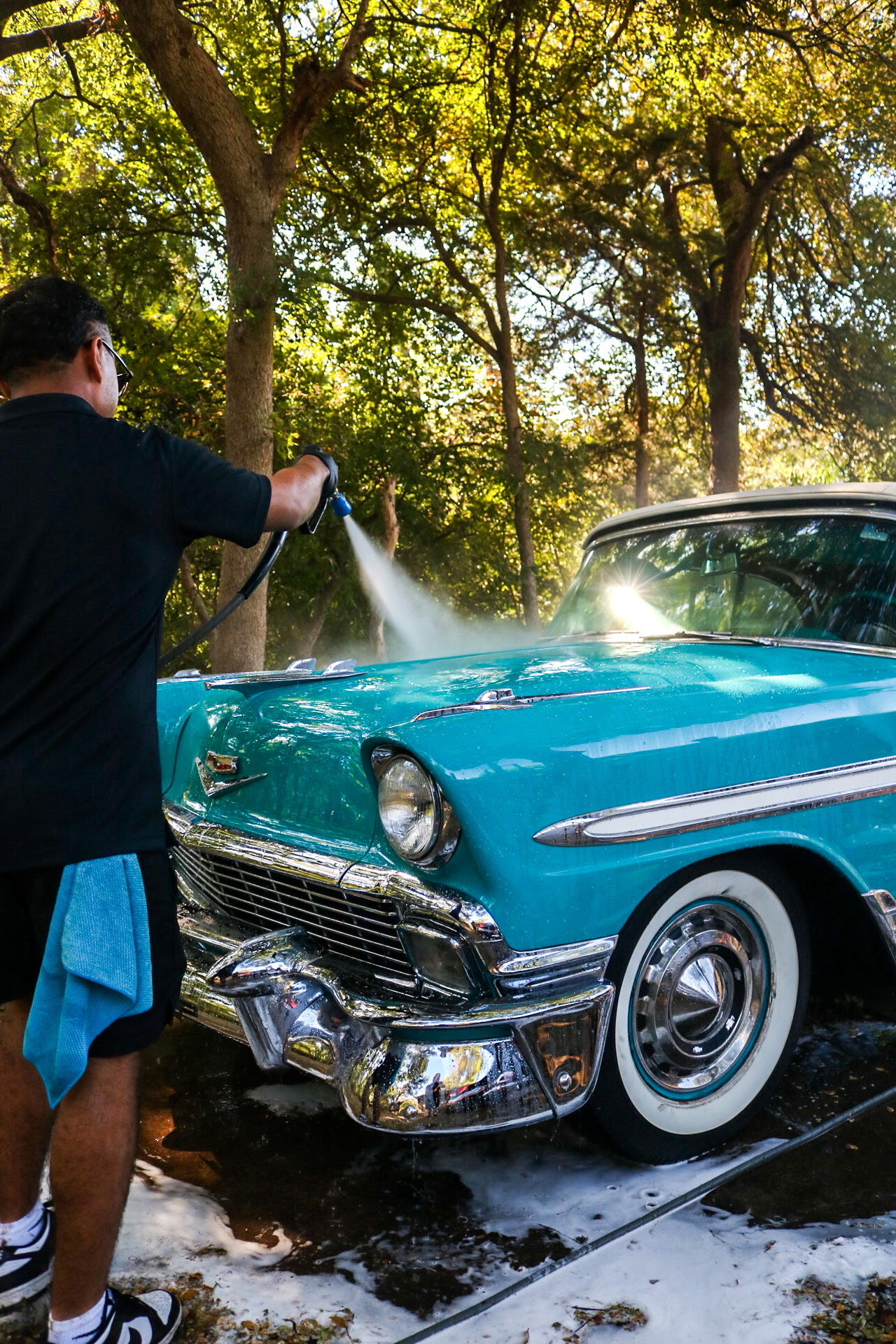 Solar City detailer pressure washing the exterior of a vehicle.