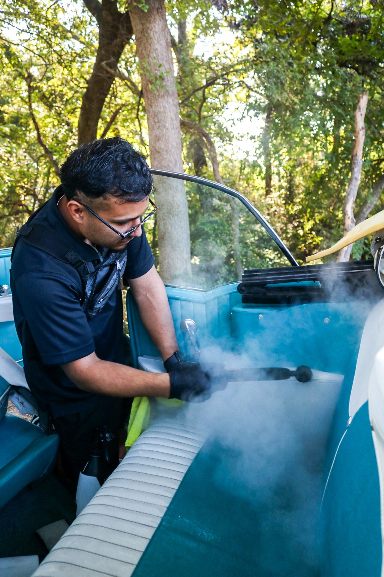 Steam cleaning upholstery during an interior auto detailing service.